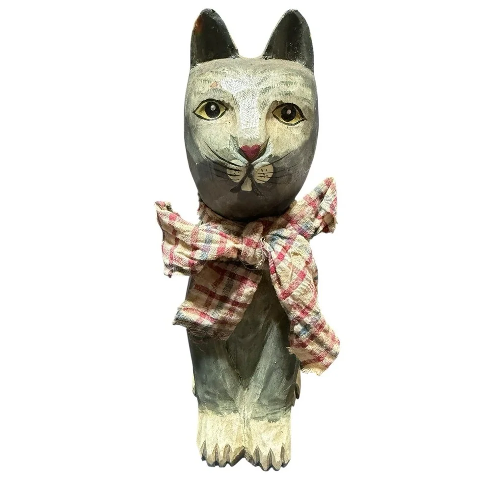 hand-carved‎ wooden cat figurine with a painted finish and a plaid cloth scarf.
